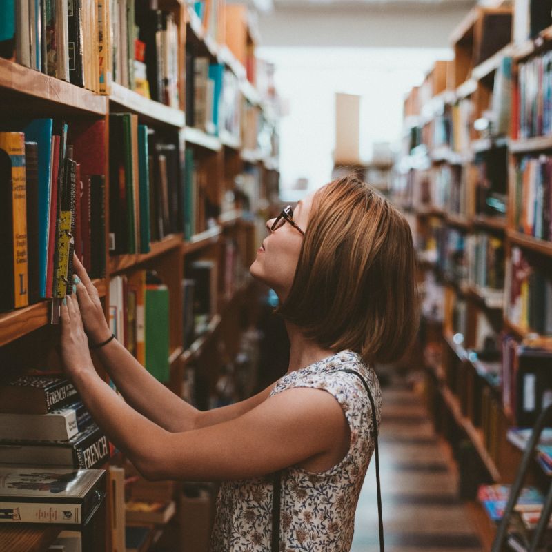 Adult looking at books in a library