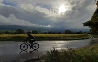 Lone cyclist on an English country road passing beautiful scenery.